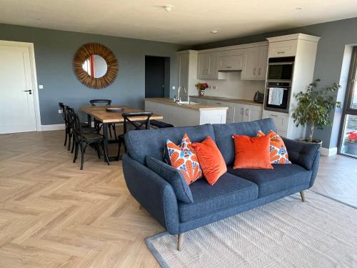加尔伊沃耶Garryvoe - Ballycotton Bay & Island View的客厅里配有带橙色枕头的蓝色沙发
