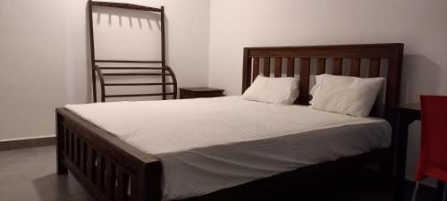 卡图纳耶克Shady transit hotel的一张带白色床单的床和一把椅子