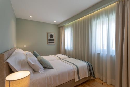 里斯本Ajuda Luxury Appartments的一间卧室设有一张床和一个大窗户