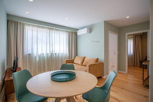 里斯本Ajuda Luxury Appartments的客厅配有桌椅和沙发