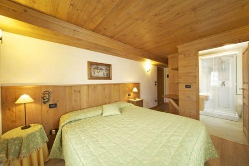 库马约尔巨人之齿酒店的一间卧室设有一张大床和木制天花板
