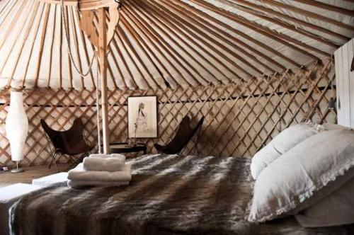 Penne-dʼAgenaisLe Relais de Roquefereau的蒙古包内一间卧室,配有一张床和椅子