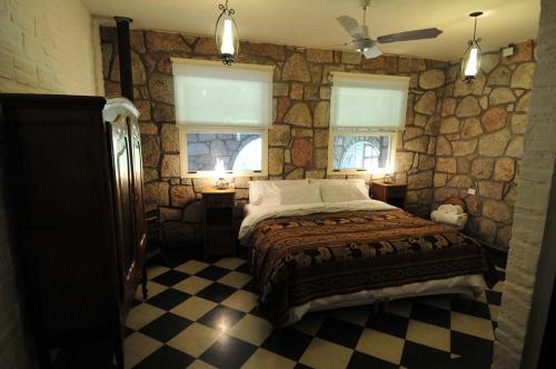 ConetaLa Aguada Hotel Boutique de Montana的一间卧室设有一张床和石墙