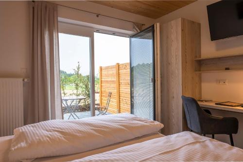 FloßFamiliengasthof Schaller的一间卧室设有一张床,享有阳台的景色