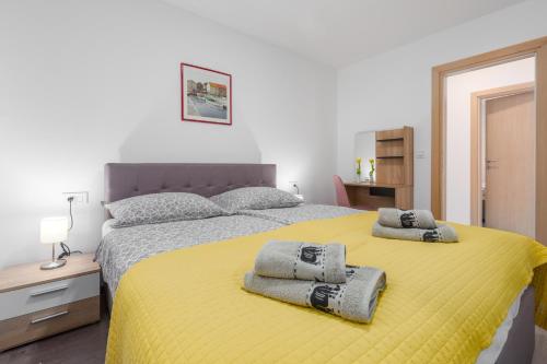 波雷奇Alex Deluxe Apartments on Beach的一间卧室配有黄色的床和毛巾