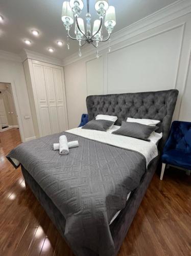 阿拉木图Apartments in the Babylon residential complex的一间卧室配有一张大床和一个吊灯。