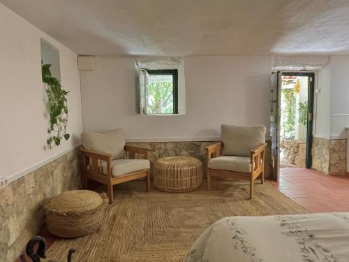 纳扎雷Nativo - Nature Studio with Kitchenette and private external bathroom的一间卧室配有一张床、两把椅子和一个窗户