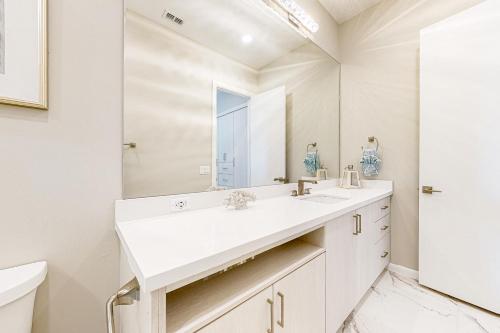 南帕诸岛Dolphin Paradise Unit A的白色的浴室设有水槽和镜子