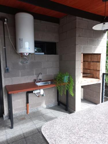 特尔马斯德里奥翁多casa de fin de semana的一个带水槽和砖墙的户外厨房