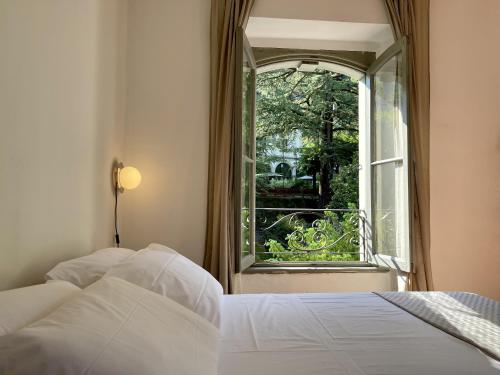圣佩莱格里诺温泉[AvocadoHouse] Incredibile Appartamento Con Vista的一间卧室设有一张床和一个开放式窗户。