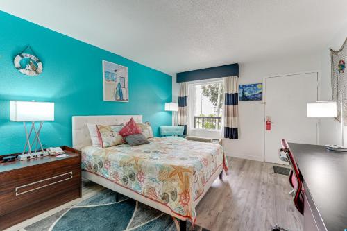 萨拉索塔Sarasota Cay Club #612 - Heated Pool, Bunk Beds, Huge TV, Tiki Bar, More!的一间卧室设有一张床和蓝色的墙壁
