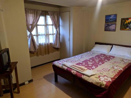 昆卡雀雷恩西亚旅馆的一间卧室设有一张床和一个窗口