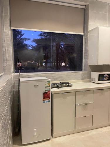 哈伊勒منتجع شرفا السياحي البيئي的厨房配有白色冰箱和窗户。