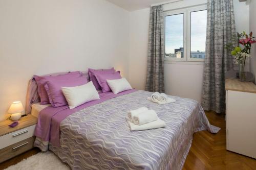 斯普利特Apartments with WiFi Split - 14127的一间卧室配有一张大床和毛巾