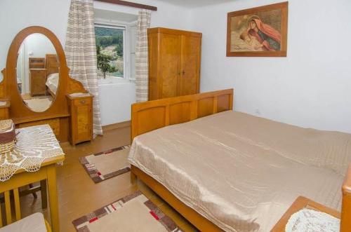 特雷斯塔尼克Seaside holiday house Trstenik, Peljesac - 16309的一间卧室配有一张床和镜子