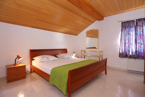 杜埃Apartments by the sea Duce, Omis - 16406的一间卧室设有一张大床和木制天花板