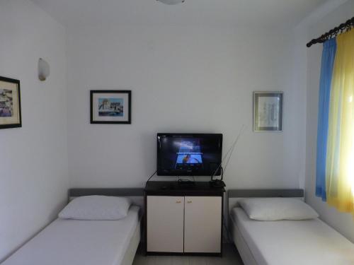 维利伊兹Apartment Mali Iz 16535b的一间设有两张床和一台电视的房间