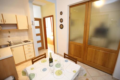 维利伊兹Apartment Mali Iz 16535b的厨房配有一张桌子,上面放着一瓶葡萄酒