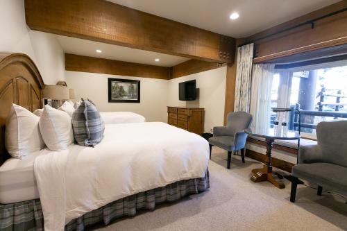 帕克城Deluxe Two Queen Room Hotel Room的卧室配有一张白色大床和一张书桌