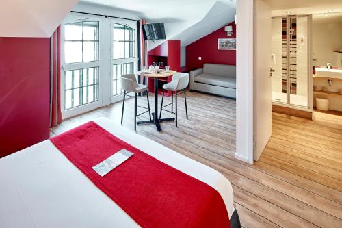 圣让-德吕兹Hotel Donibane Saint-Jean-de-Luz的酒店客房,配有一张床和一张桌子及椅子