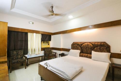 比拉斯布尔Hotel Natraj的一间卧室配有一张大床和一把椅子