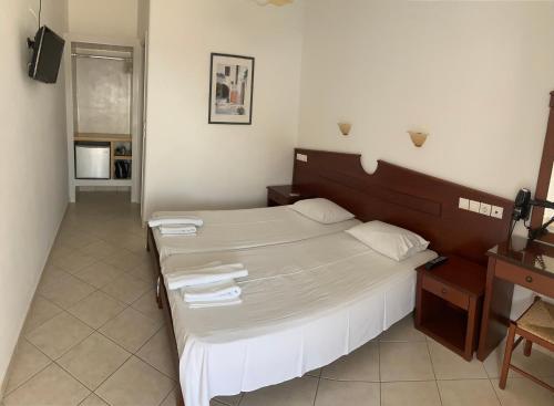 迈洛波塔斯伊尔皮斯酒店的一间卧室配有一张大床和毛巾