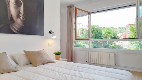 毕尔巴鄂Mood Bilbao Apartamentos - New & Special的一间卧室设有一张大床和大窗户