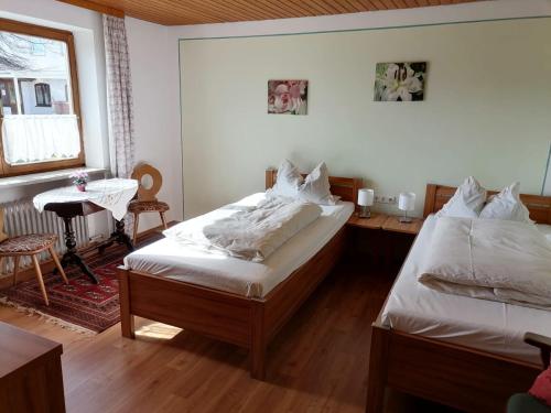 SchonstettGasthof zur Post的一间卧室设有两张床、一张桌子和一个窗口