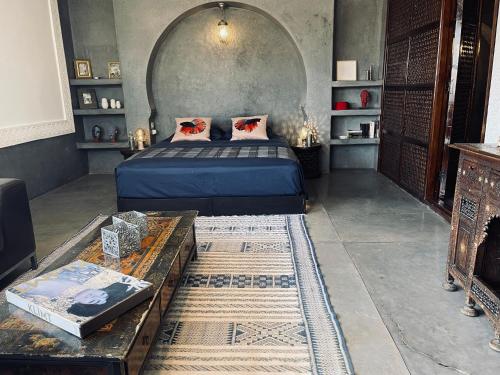 马拉喀什144号摩洛哥传统庭院旅馆的一间卧室配有一张床和一张桌子