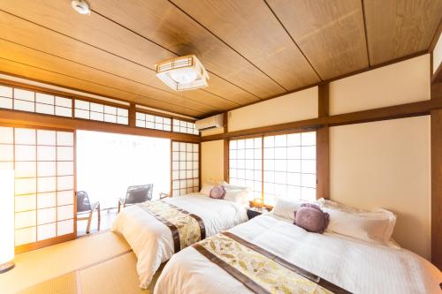 岬町Misaki no OKA 185的带窗户的客房内的两张床