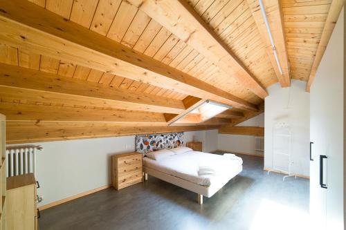 米兰达塞纳假日及商务会所公寓的大型客房设有床和木制天花板。
