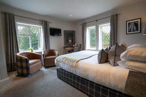 哈罗盖特The Inn South Stainley的一间卧室配有一张床、一把椅子和窗户。