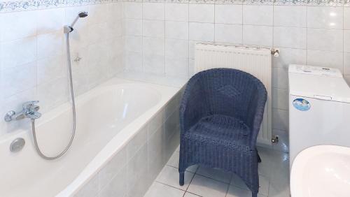 LieserhofenMalerisches Bauernhaus的浴室设有蓝色椅子,位于浴缸旁
