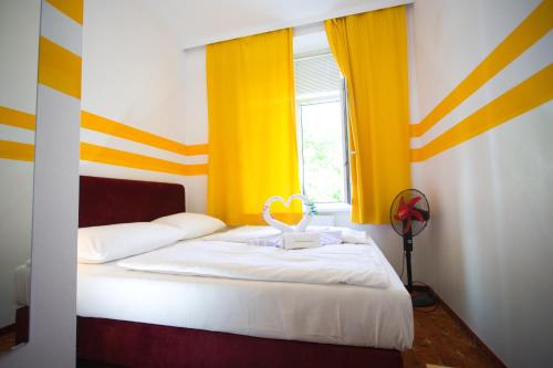 维也纳城居酒店的一间卧室配有一张黄色和白色条纹的床