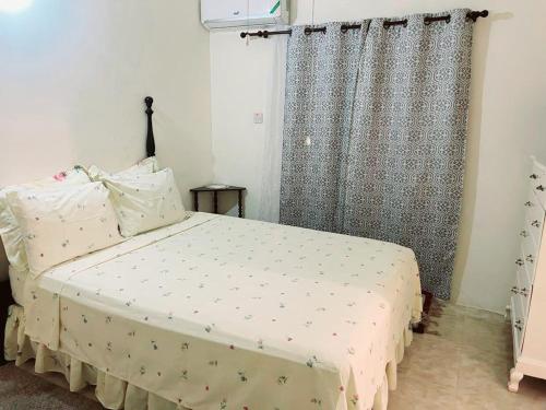 Florence HallL&V Paradise Vacation # 1的一间卧室配有床和带窗帘的窗户