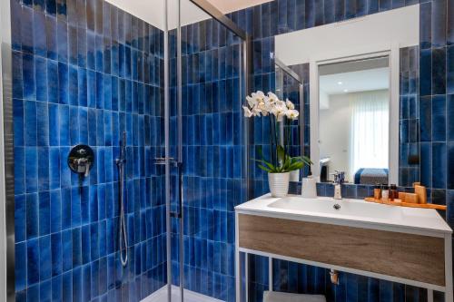 索伦托Dreamers' Rooms Sorrento的蓝色瓷砖浴室设有水槽和淋浴