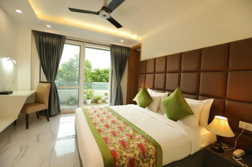 古尔冈Hotel Keshav Residency near Medanta Pure Veg的一间卧室配有一张床、一张书桌和一个窗户。