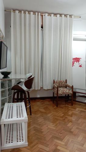 里约热内卢#Apartamento aconchegante no Flamengo - RIO的客厅铺有木地板,配有白色窗帘