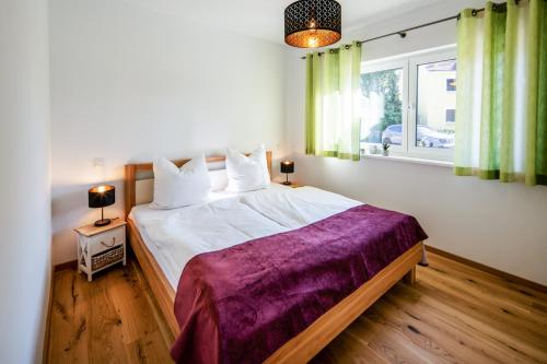 萨勒河畔瑙姆堡Chalet Altalmrich的一间卧室配有一张大床和紫色毯子