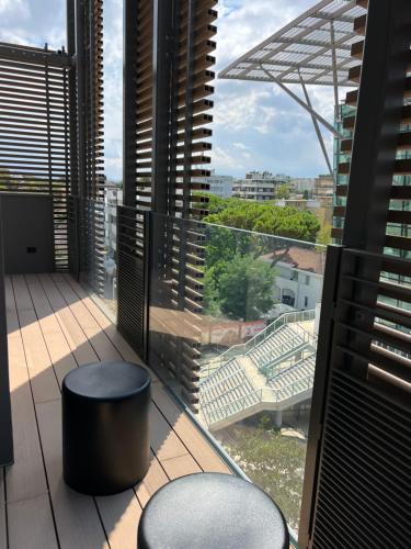 里乔内Ceccarini 9 home suite home的阳台设有2张凳子,享有体育场的景致。