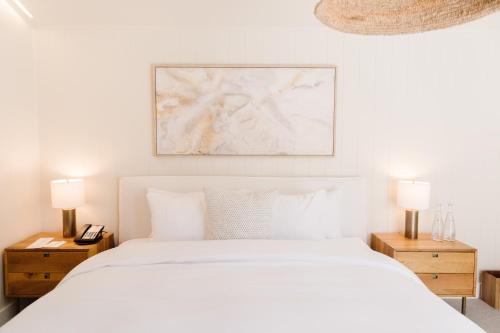 马里布卡拉明哥游客牧场和海滩俱乐部度假村的白色卧室,配有白色的床和2个床头柜