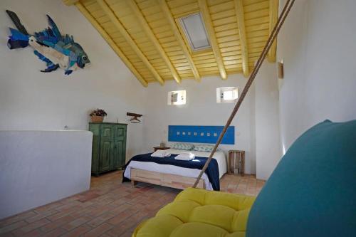维拉多比斯坡Casa Amado, Aldeia da Pedralva的一间卧室配有一张床和一个沙发