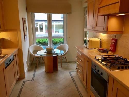 爱丁堡Hopetoun Apartment with free parking的厨房配有桌子和小桌子及椅子