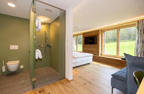达沃斯凯斯勒库尔姆酒店的浴室设有步入式淋浴间,位于窗户旁