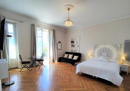 艾克斯莱班Grand studio 38m2 dans ancien palace avec piscine et place de parking privée的卧室配有白色的床和沙发