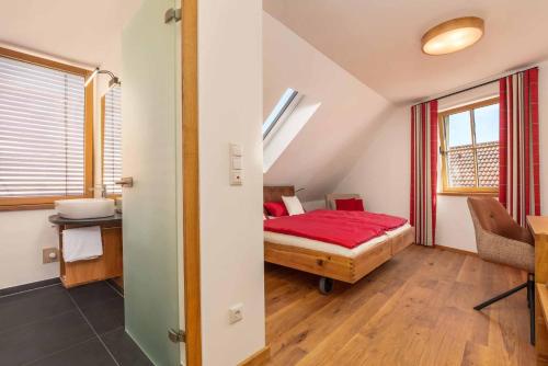 瓦尔德明兴Hotel Garni zum Schwan的一间卧室配有一张带红色毯子的床