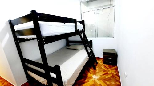 帕卡斯马约Departamento en Pacasmayo的窗户客房内的一张黑色双层床