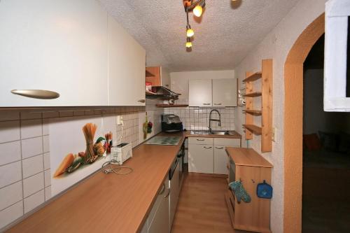 齐勒谷地里德Kuanerhof Wohnung 2-4 Personen的厨房配有白色橱柜和木制台面