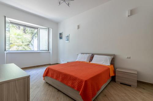 米兰CityLife, Fiera City, MiCo & San Siro Apartment的一间卧室配有一张带橙色毯子和窗户的床。