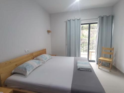 PombasLuz d'Sol - Residencial Familiar的卧室配有床、椅子和窗户。